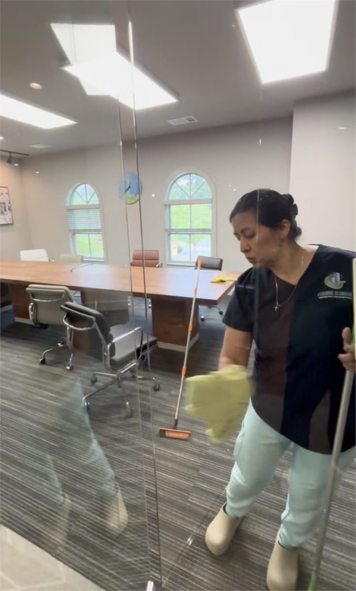 Starbiz cleaner detailing a glass conference-room wall